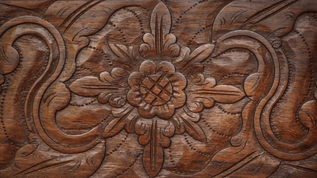 Surface en bois avec des sculptures florales complexes et des motifs tourbillonnants.