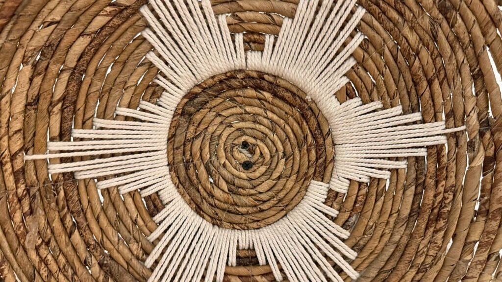 Gros plan d'un panier tressé avec un motif circulaire et un motif géométrique blanc rayonnant à partir du centre.