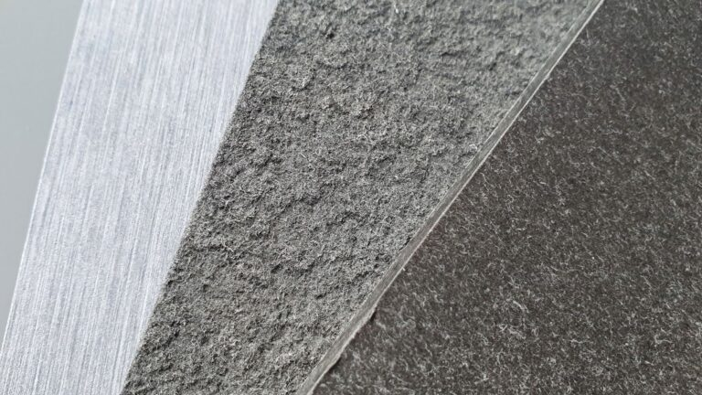 Gros plan de trois surfaces texturées qui se croisent : une surface claire et rugueuse ; un milieu plus foncé et grossier ; et une zone sombre et lisse.