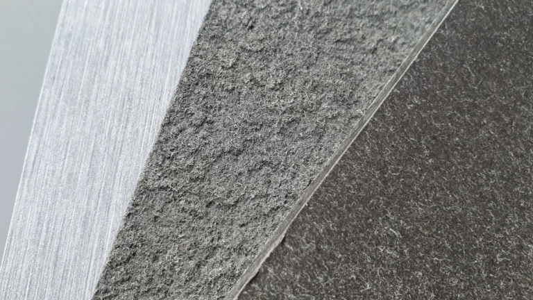 Gros plan de trois surfaces texturées qui se croisent : une surface claire et rugueuse ; un milieu plus foncé et grossier ; et une zone sombre et lisse.