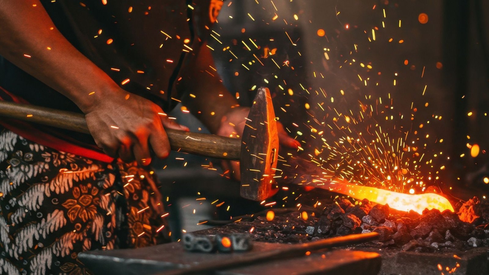 Un forgeron martèle une tige de métal incandescente sur une enclume, entouré d'étincelles volantes dans un atelier faiblement éclairé.
