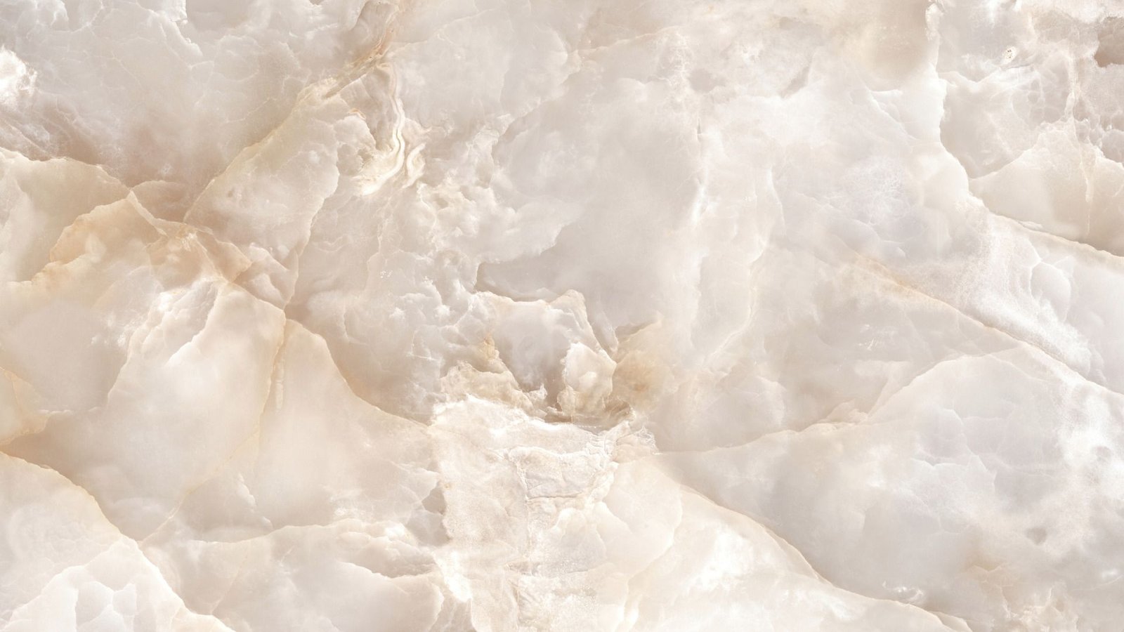 Gros plan d'une texture de marbre blanc et beige avec des motifs ondulés et des veines subtiles.
