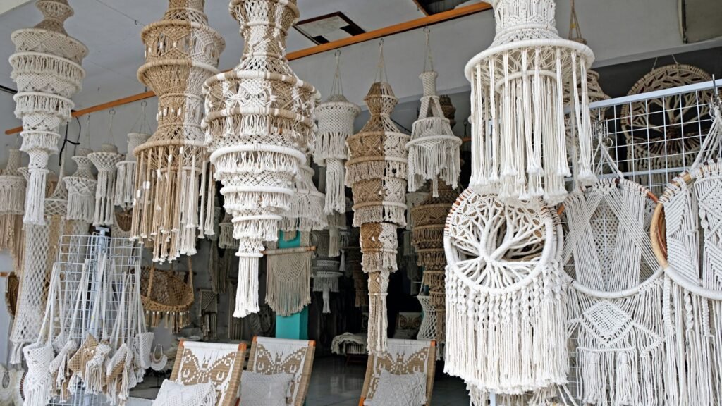 Décoration en macramé suspendue dans une boutique, présentant divers motifs et dessins complexes dans des tons neutres.